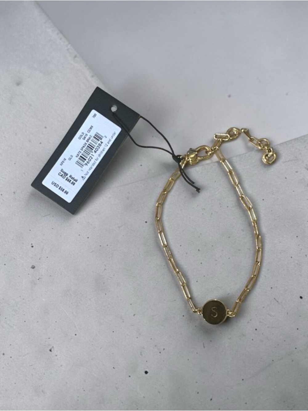 kate spade Gold Paperclip Bracelet with 'S' Disc comes with dust bag.